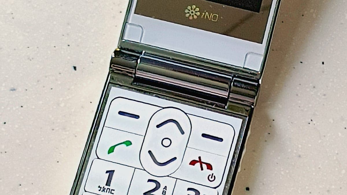 A folding flip phone open on a plain surface