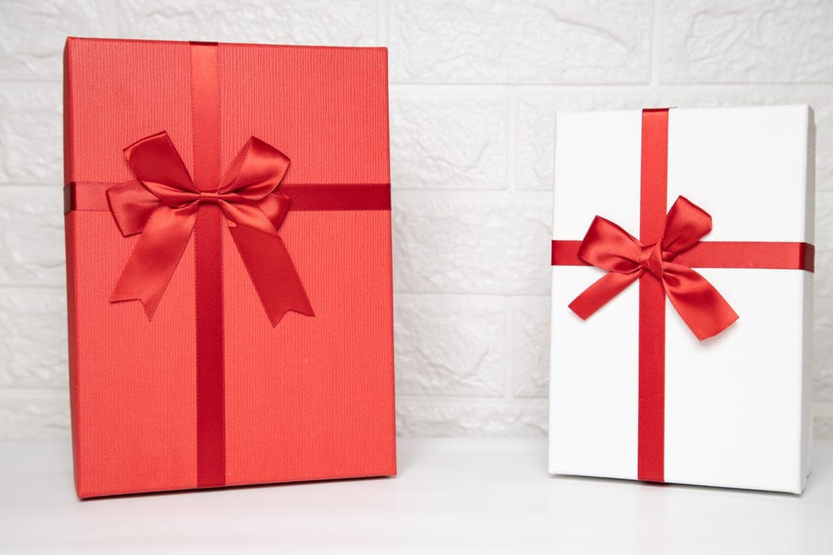 Two wrapped gift boxes tied with red ribbon