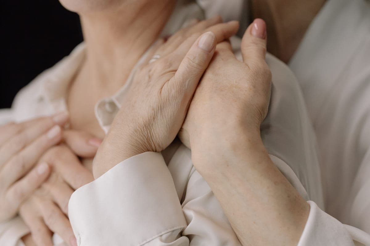 An older person's hands held in another's