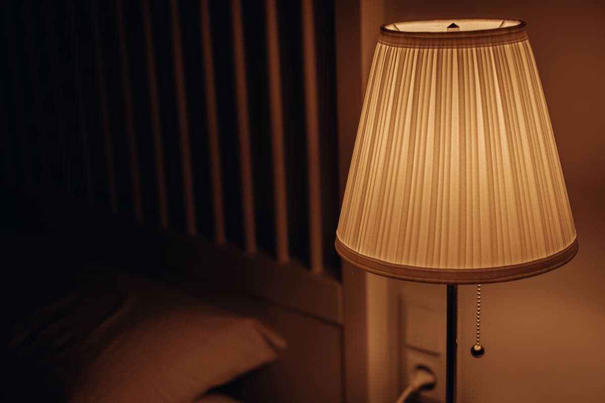 A softly lit lamp casting warm light in a bedroom at night