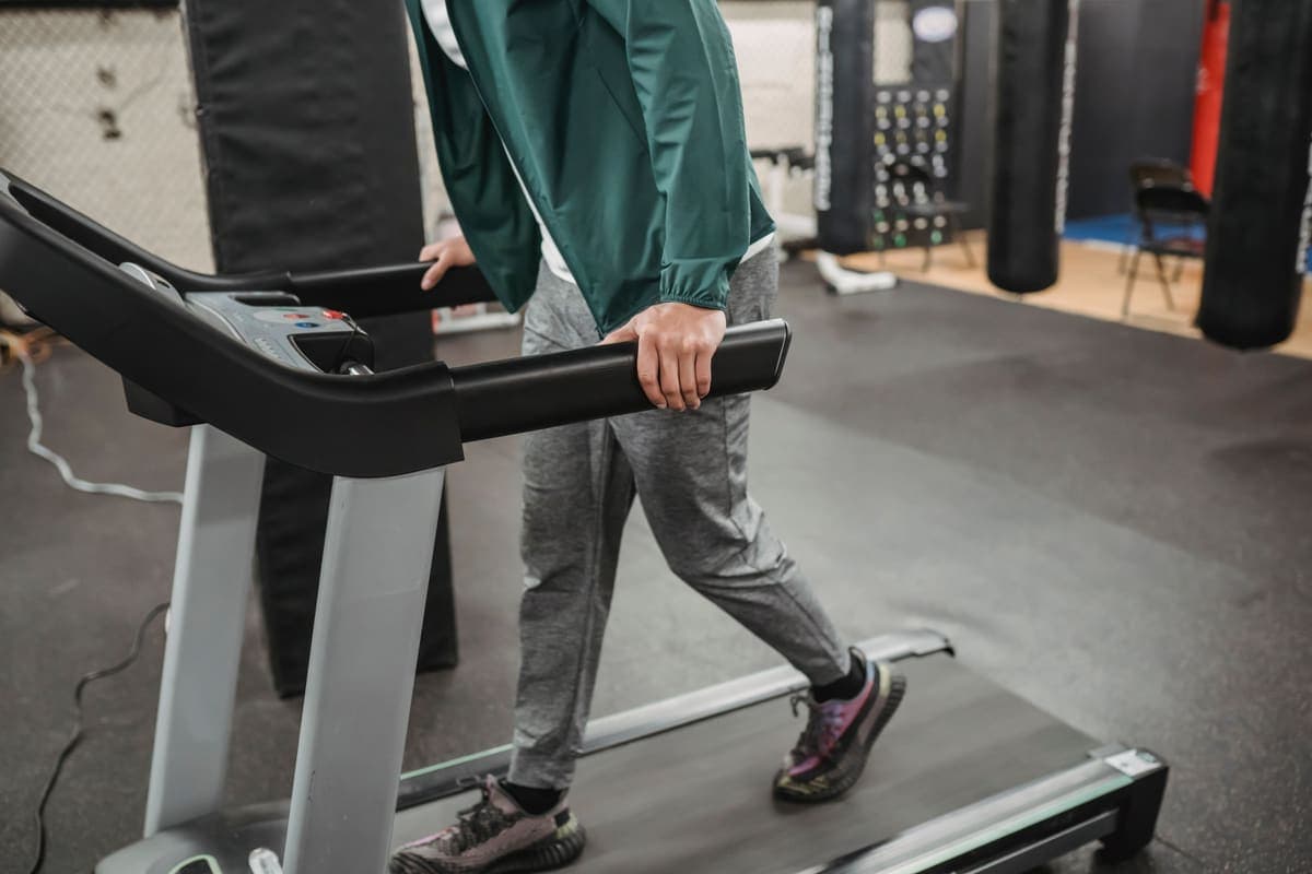 A person walking on a flat treadmill deck indoors